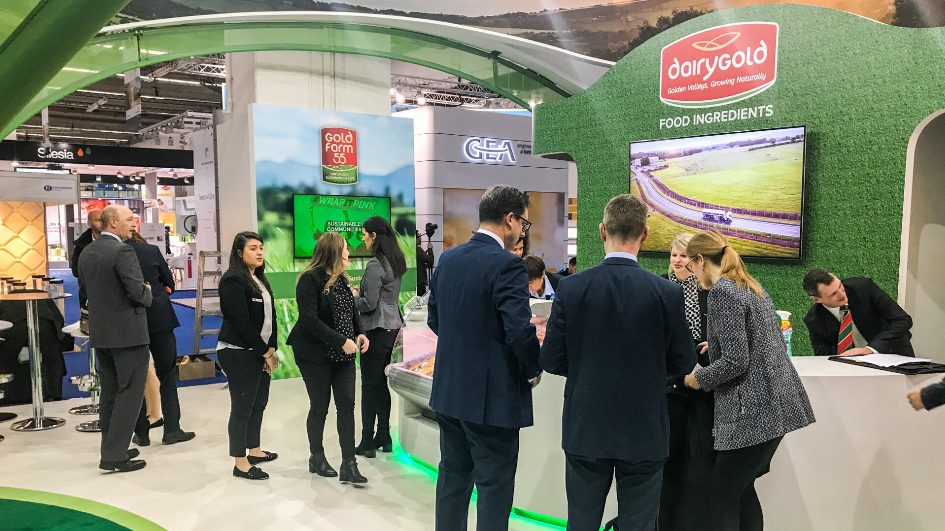 dairy gold representatives and visitors interacting with an exhibition