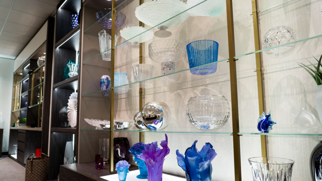 glasses vases displayed on glass shelving