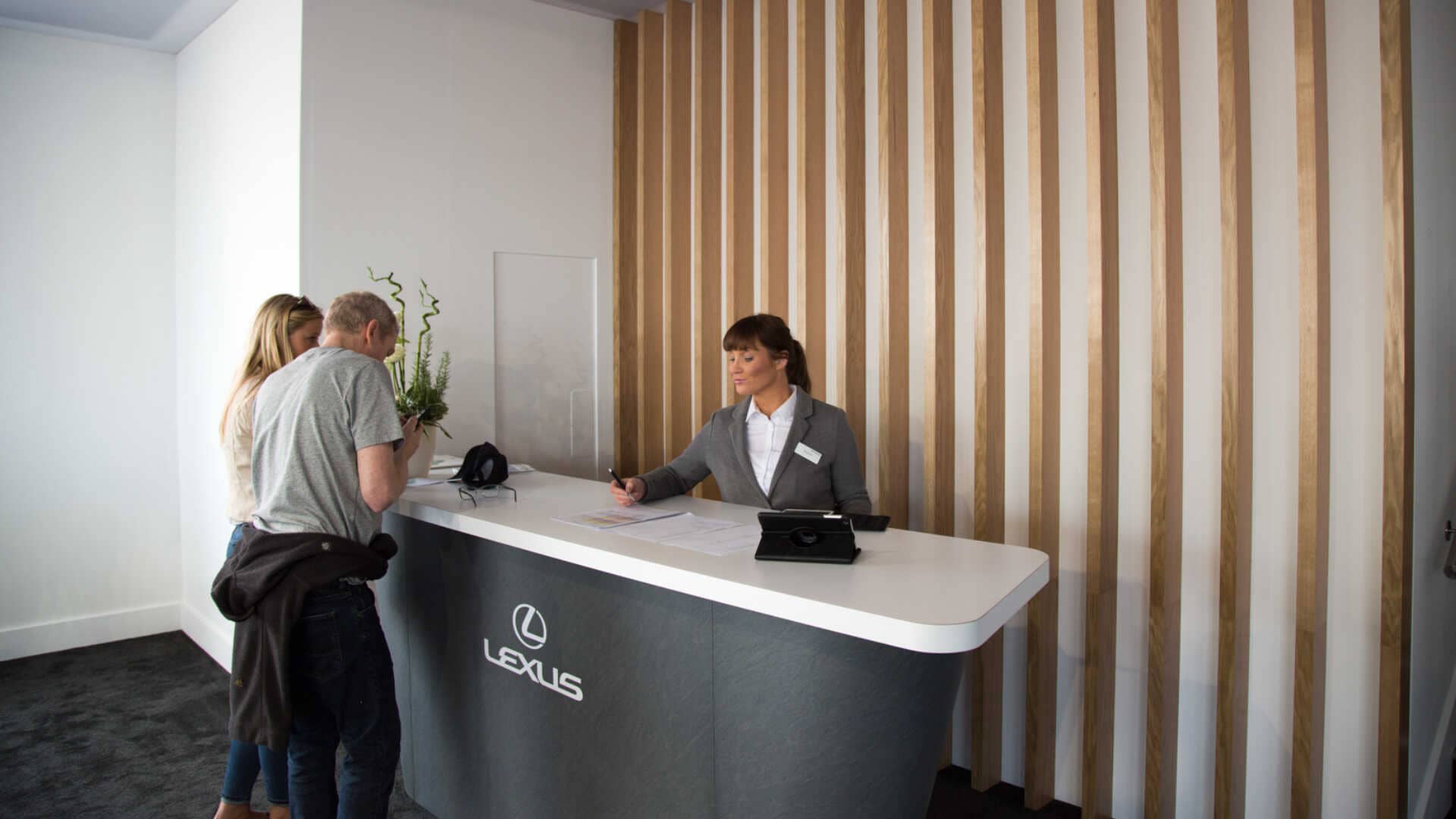 lexus representative at the front desk accommodating visitor