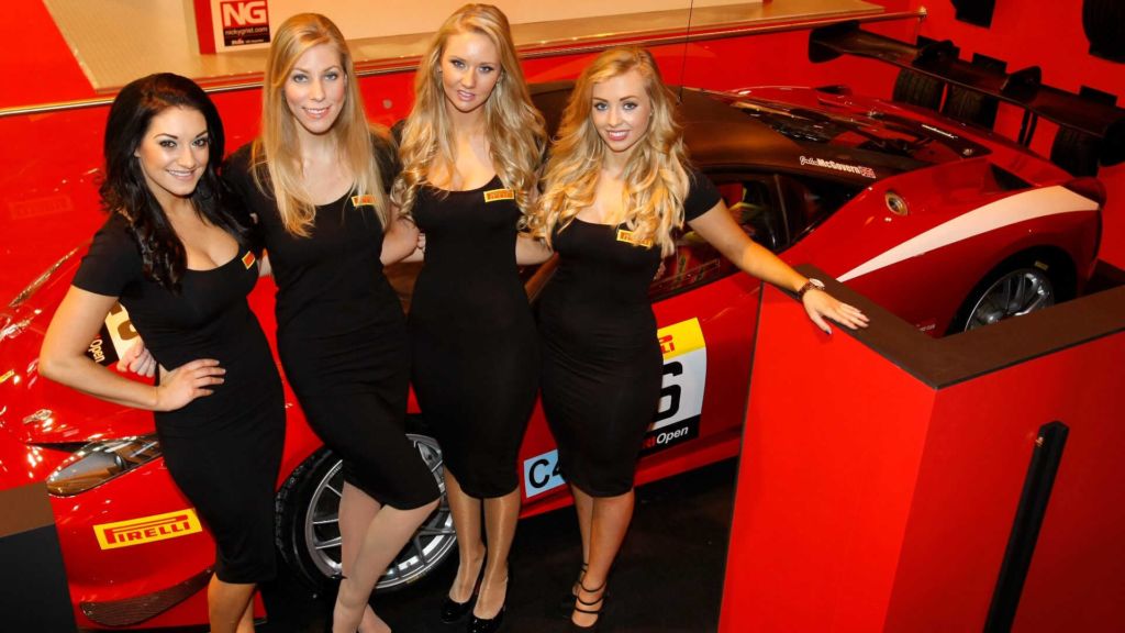 pirelli models in front of a sports car