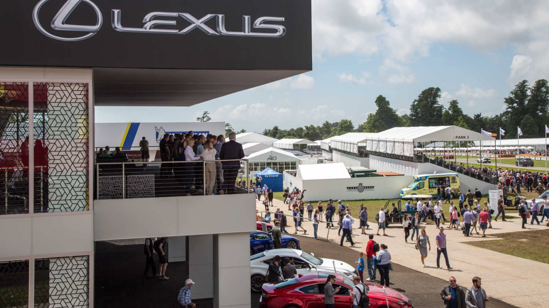 side profile of the lexus exhibition with visitors on the balcony and outside